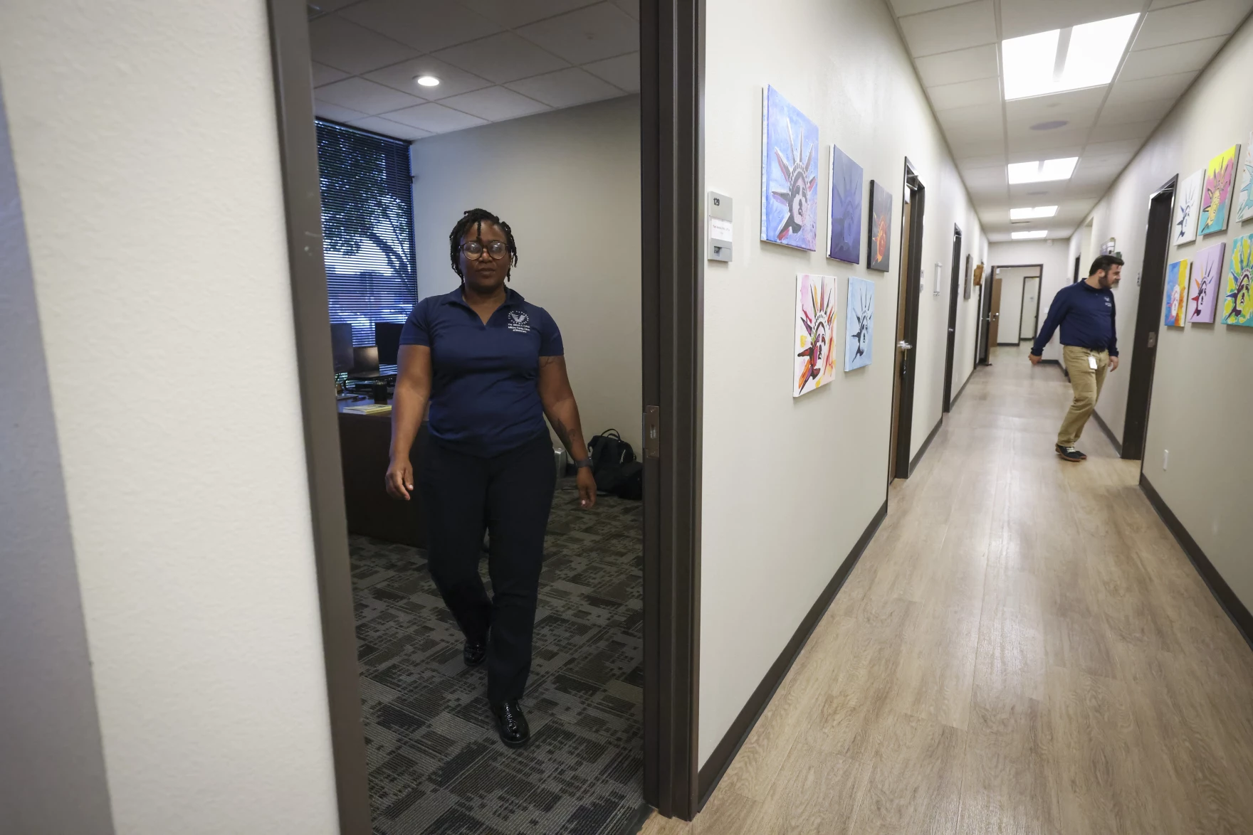 Person walking out of open office into long hallway